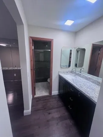 a bathroom with a granite countertop sink a toilet and shower