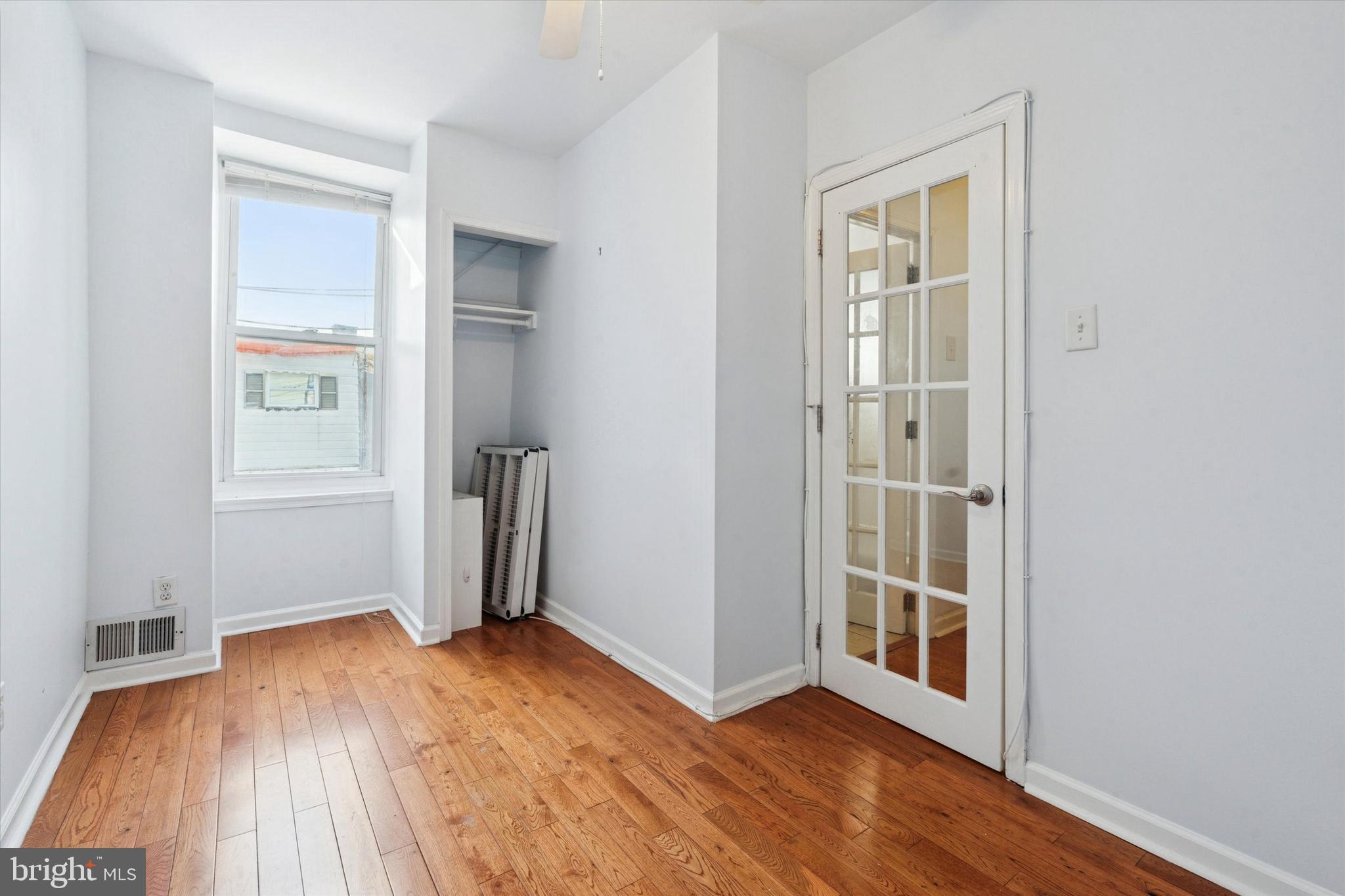 102 Daly Street Philadelphia, PA 19148 - Photo 16 of 25 an empty room with wooden floor and a window
