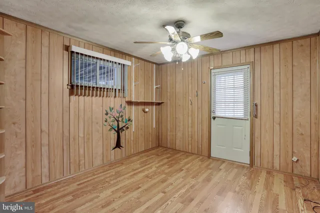 a view of empty room with a window and chandelier fan