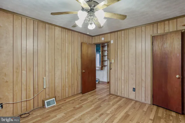 a view of a hallway with a chandelier fan and windows