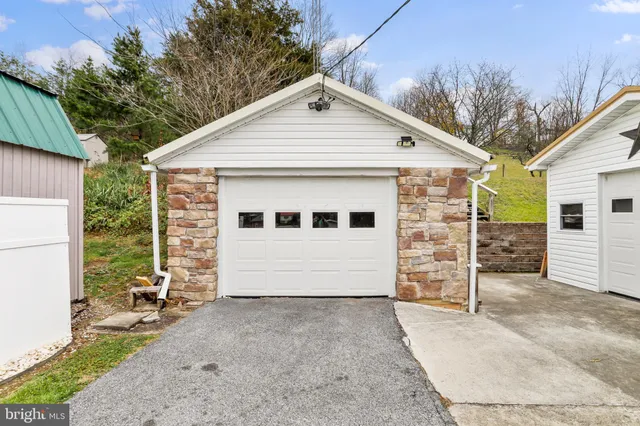a view of a white house with a large space and a garage