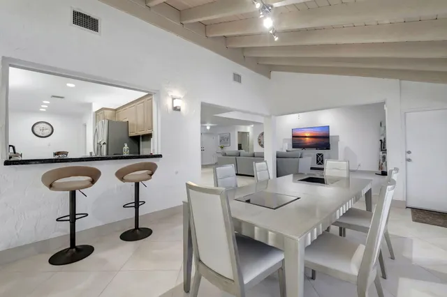 a kitchen with a sink a counter space and a view of living room