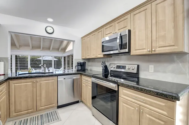 a kitchen with stainless steel appliances granite countertop a stove and a microwave