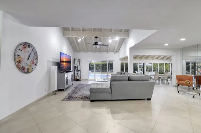 a living room with furniture a flat screen tv and a large window