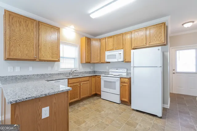 a kitchen with stainless steel appliances granite countertop a refrigerator sink stove and microwave