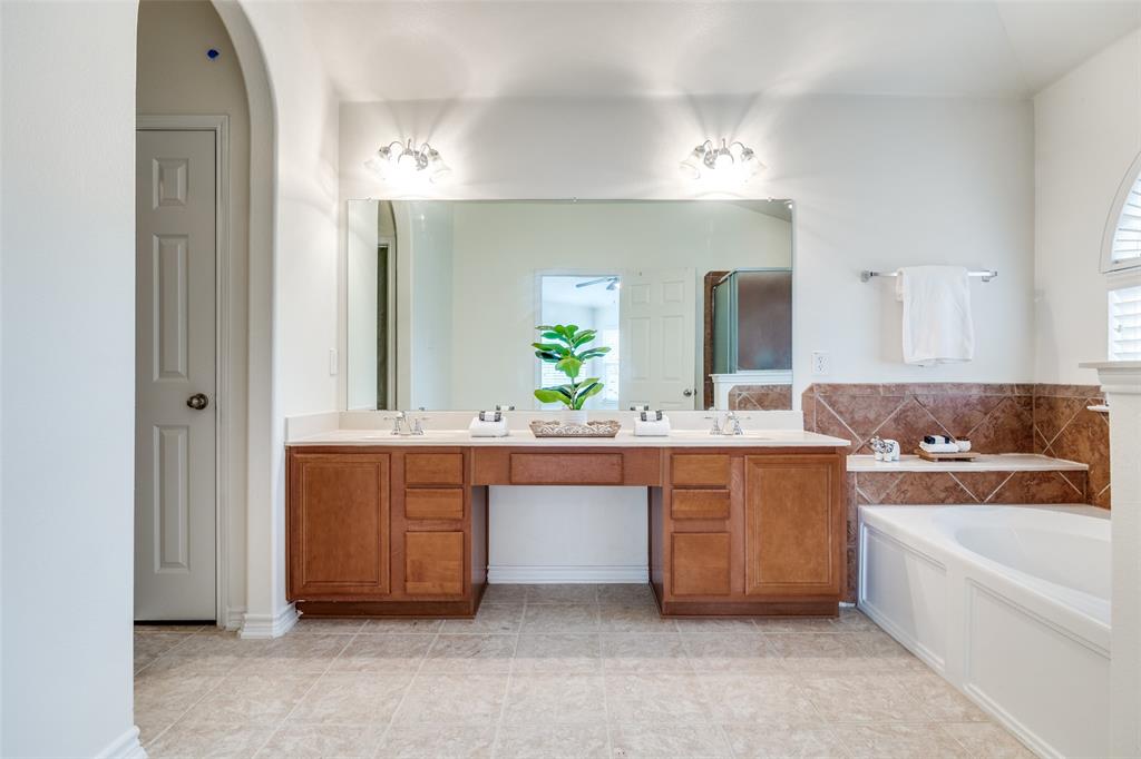 2025 Testament Trail Plano, TX 75074 - Photo 20 of 29 a bathroom with a bathtub a double vanity sink and a mirror