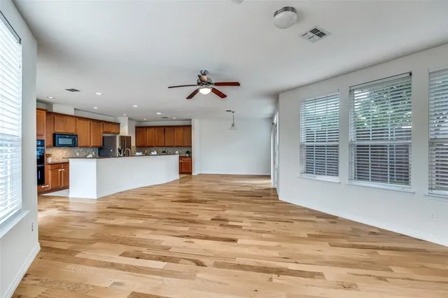 a view of a kitchen with kitchen island a sink stainless steel appliances and cabinets