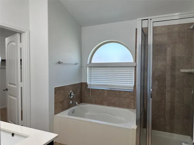 a bathroom with a tub a sink and a window