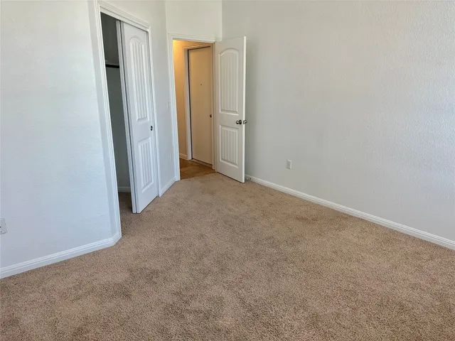 an empty room with closet and mirror