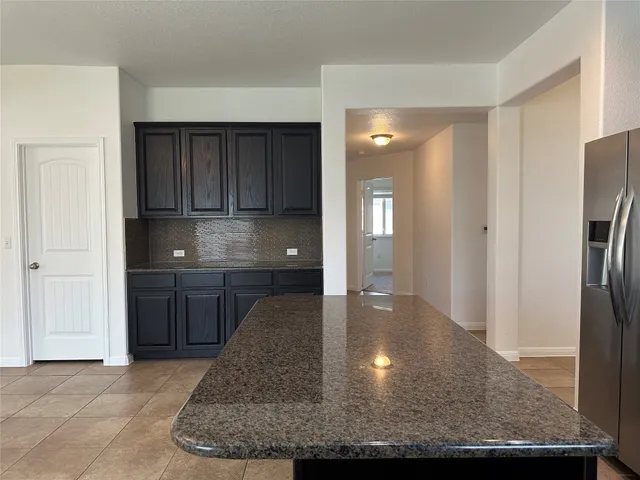 a kitchen with kitchen island a counter top space cabinets and a refrigerator