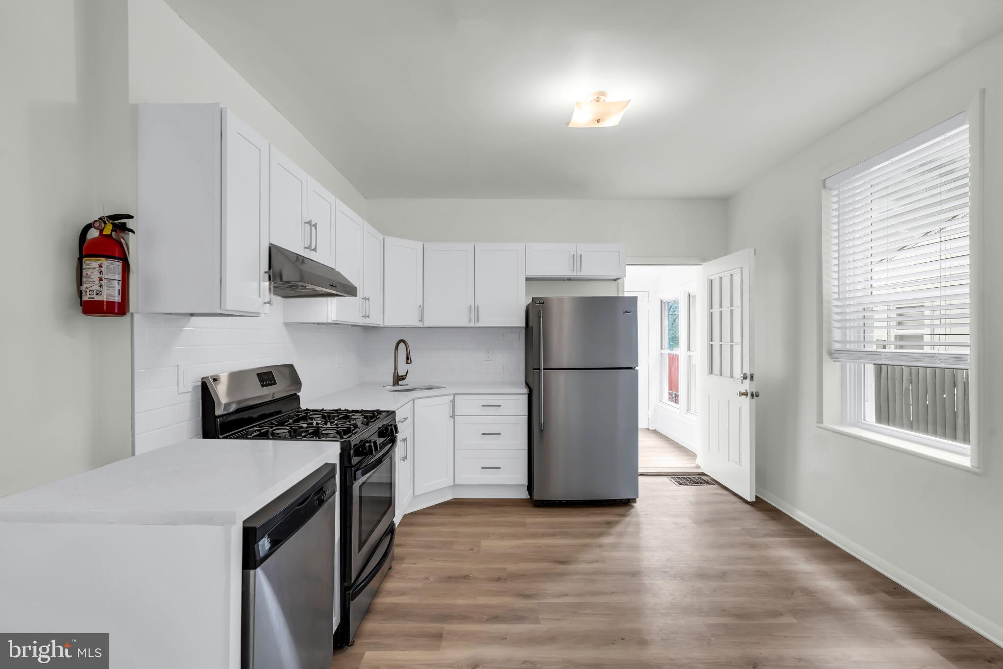 503 Kossuth Street Riverside, NJ 08075 - Photo 6 of 18 a kitchen with a refrigerator a stove a microwave and a window