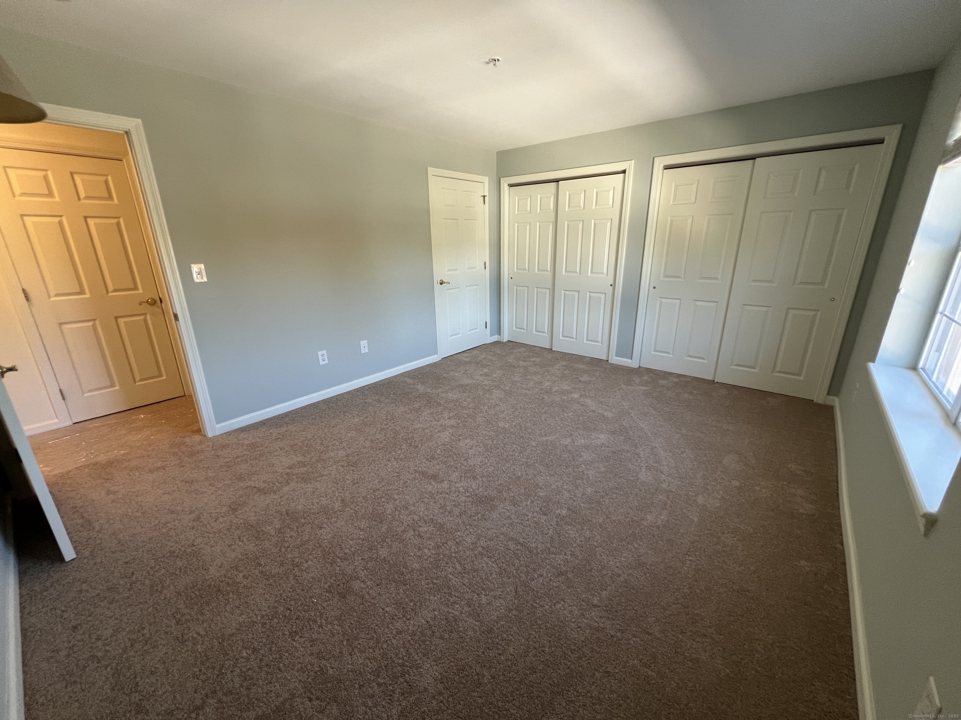 75 Washington Avenue, Unit 8403 Hamden, CT 06518 - Photo 8 of 18 a view of an empty room with wooden door