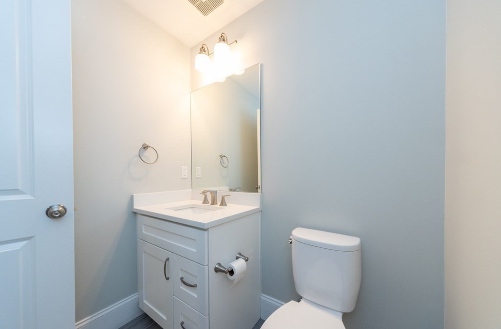 156 Ash Street, Unit 2 Waltham, MA 02453 - Photo 18 of 39 a bathroom with a toilet sink and mirror