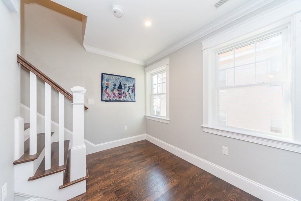 156 Ash Street, Unit 2 Waltham, MA 02453 - Photo 19 of 39 an empty room with wooden floor and windows
