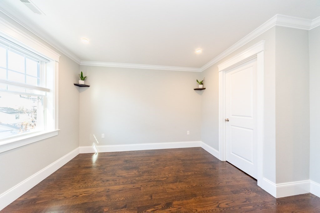 156 Ash Street, Unit 2 Waltham, MA 02453 - Photo 21 of 39 an empty room with wooden floor and windows