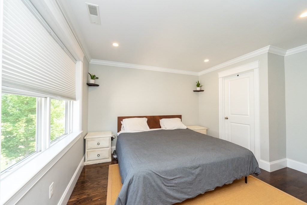 156 Ash Street, Unit 2 Waltham, MA 02453 - Photo 25 of 39 a bed sitting in a bedroom next to a window