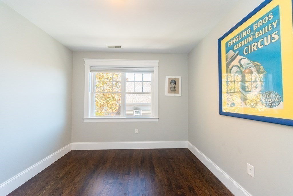 156 Ash Street, Unit 2 Waltham, MA 02453 - Photo 26 of 39 an empty room with wooden floor and windows