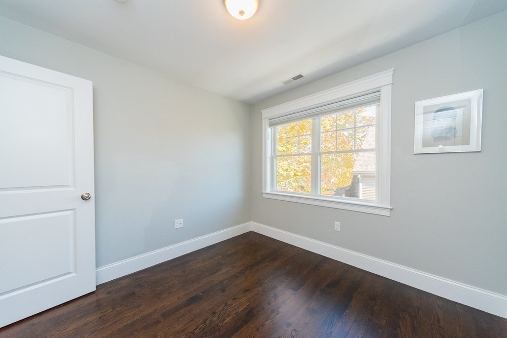 156 Ash Street, Unit 2 Waltham, MA 02453 - Photo 27 of 39 a view of an empty room with wooden floor and a window