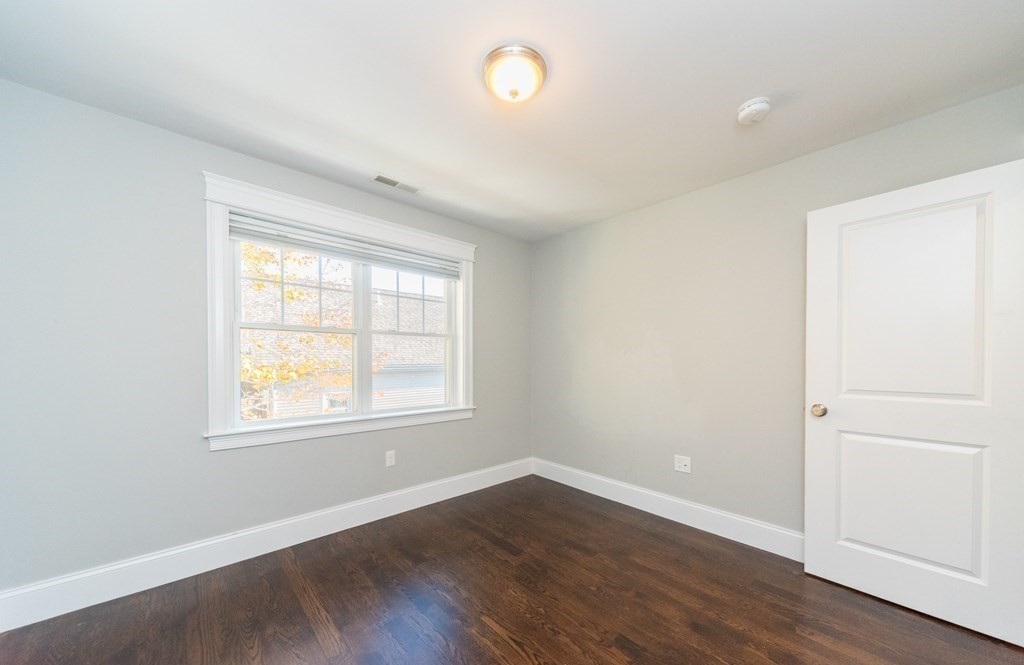 156 Ash Street, Unit 2 Waltham, MA 02453 - Photo 28 of 39 an empty room with wooden floor and windows