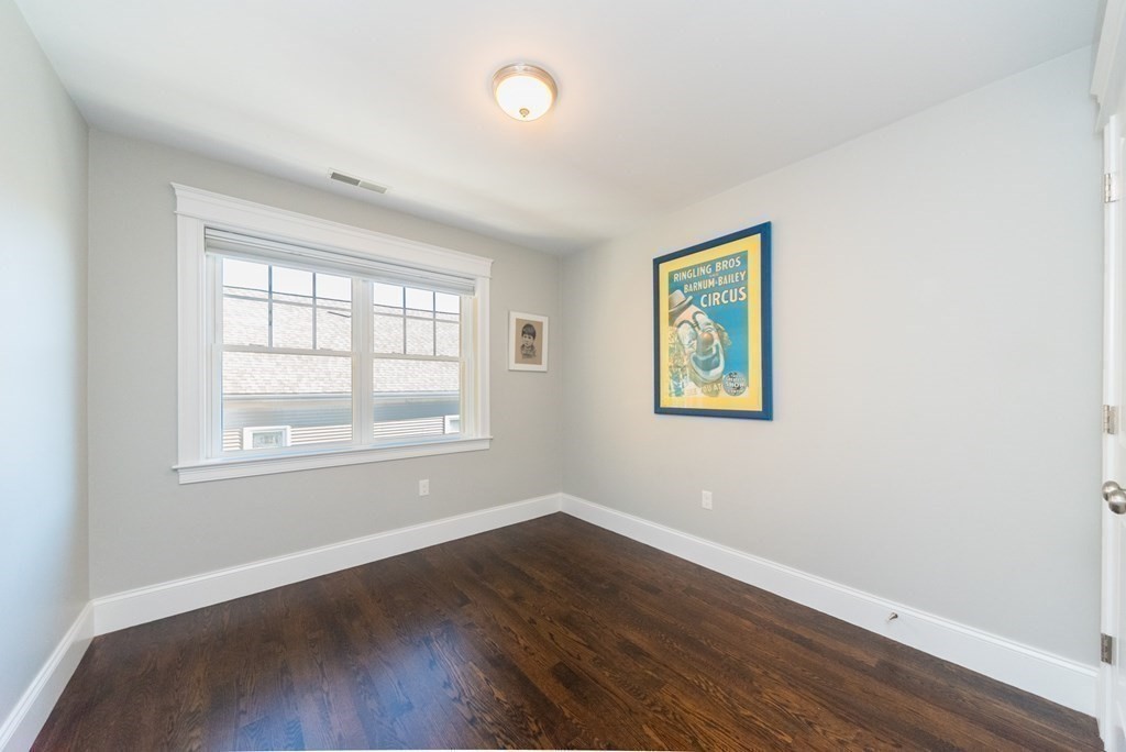 156 Ash Street, Unit 2 Waltham, MA 02453 - Photo 29 of 39 an empty room with wooden floor and windows