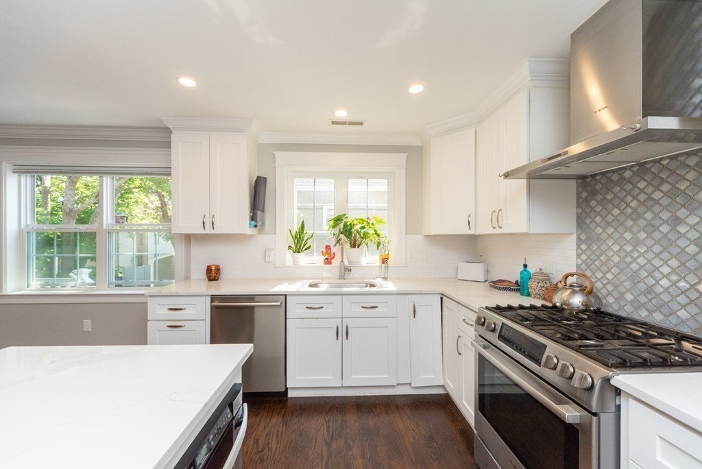 156 Ash Street, Unit 2 Waltham, MA 02453 - Photo 3 of 39 a kitchen with a stove a sink a window and cabinets