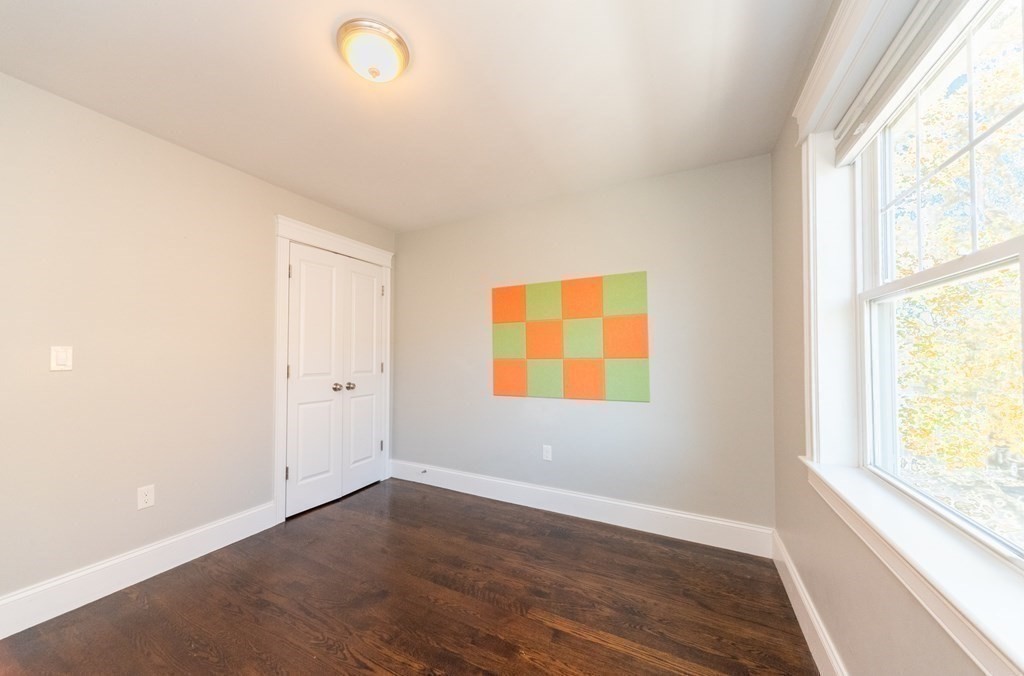 156 Ash Street, Unit 2 Waltham, MA 02453 - Photo 31 of 39 a view of an empty room with wooden floor and a window
