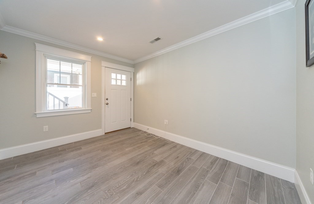 156 Ash Street, Unit 2 Waltham, MA 02453 - Photo 38 of 39 an empty room with wooden floor and windows