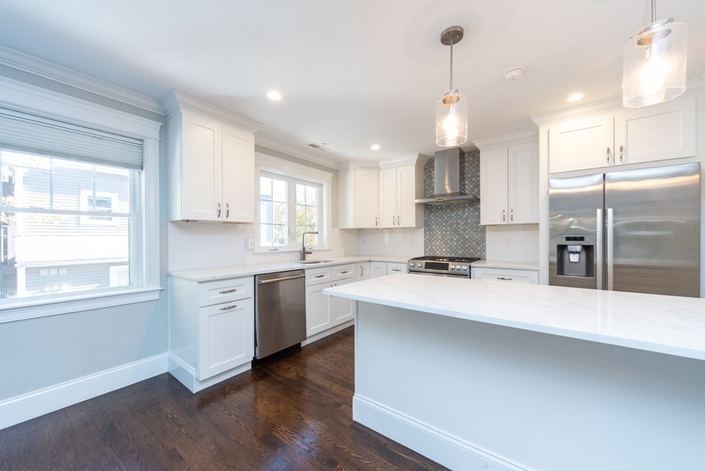 156 Ash Street, Unit 2 Waltham, MA 02453 - Photo 6 of 39 a kitchen with kitchen island a sink stainless steel appliances and window