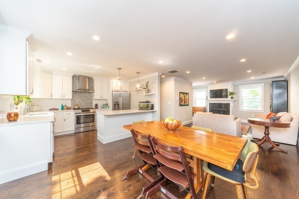 156 Ash Street, Unit 2 Waltham, MA 02453 - Photo 9 of 39 a dining hall with stainless steel appliances kitchen island granite countertop a dining table chairs and view kitchen