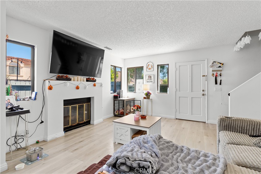 8784 Hewitt Place, Unit 12 Garden Grove, CA 92844 - Photo 27 of 54 a living room with furniture a flat screen tv and a fireplace