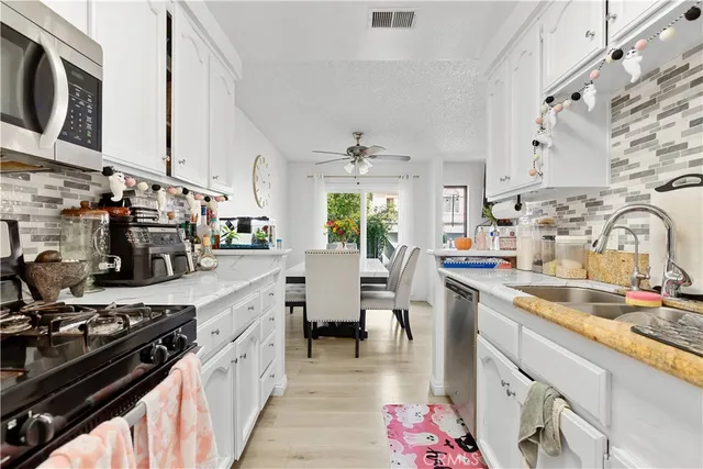 a view of a patio with couches and table and chairs and potted plants