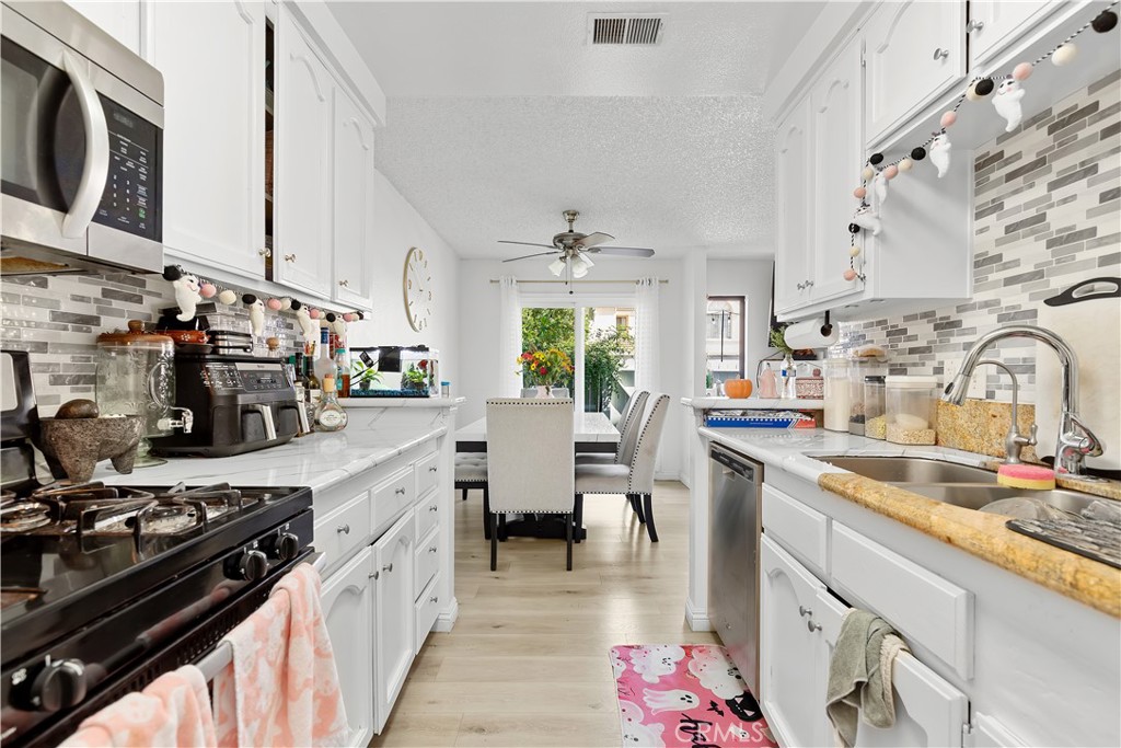 8784 Hewitt Place, Unit 12 Garden Grove, CA 92844 - Photo 28 of 54 a kitchen with a sink stove and cabinets