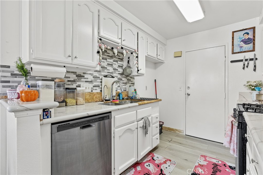 8784 Hewitt Place, Unit 12 Garden Grove, CA 92844 - Photo 30 of 54 a kitchen with stainless steel appliances a sink a stove a chimney a refrigerator and cabinets