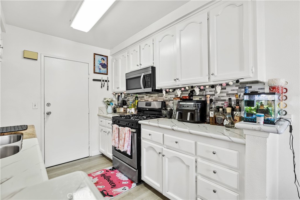 8784 Hewitt Place, Unit 12 Garden Grove, CA 92844 - Photo 31 of 54 a kitchen with stainless steel appliances granite countertop a sink a stove and a refrigerator
