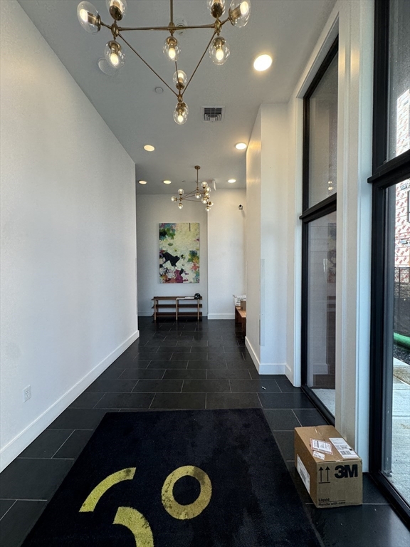30 Penniman Road, Unit 307 Boston, MA 02134 - Photo 2 of 10 a view of a hallway with wooden floor and chandelier