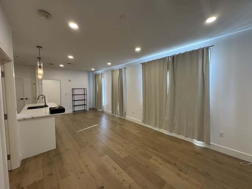 30 Penniman Road, Unit 307 Boston, MA 02134 - Photo 3 of 10 a view of an empty room with wooden floor