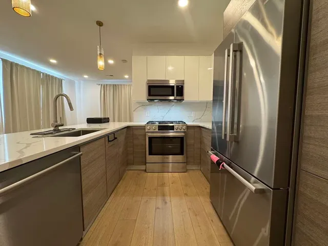 a kitchen with stainless steel appliances a refrigerator sink and microwave