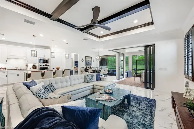 a living room with furniture kitchen view and a large window