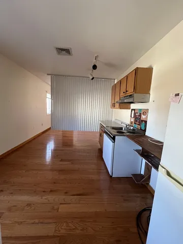a kitchen with granite countertop wooden floors and wide window