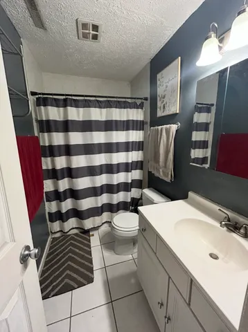 a bathroom with a sink a toilet a mirror and shower