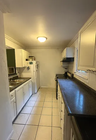 a kitchen with a sink a stove and cabinets