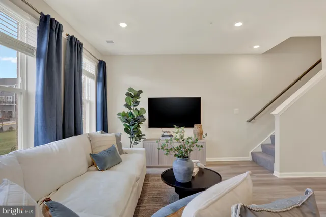 a living room with furniture a flat screen tv and a large window
