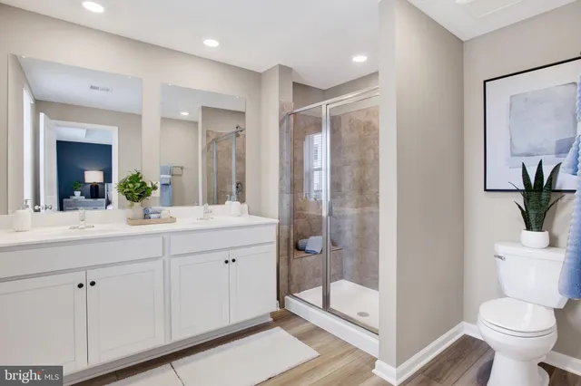 a bathroom with a double vanity sink toilet and shower