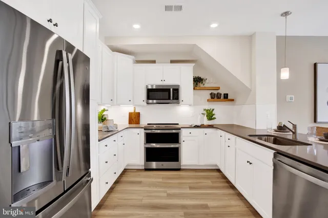 a kitchen with stainless steel appliances a stove sink microwave and cabinets