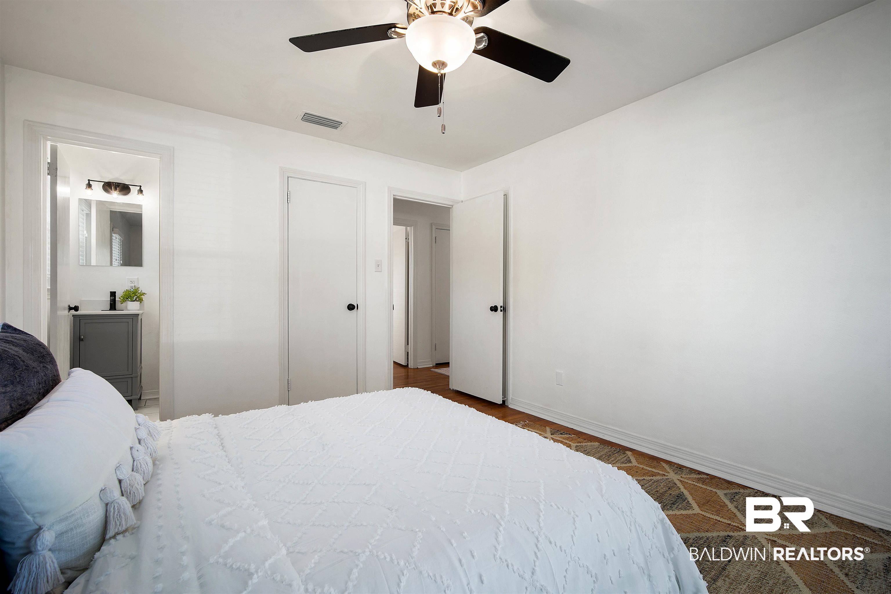 2615 Walton Avenue Mobile, AL 36606 - Photo 25 of 33 Bedroom with visible vents, ceiling fan, ensuite bath, and baseboards