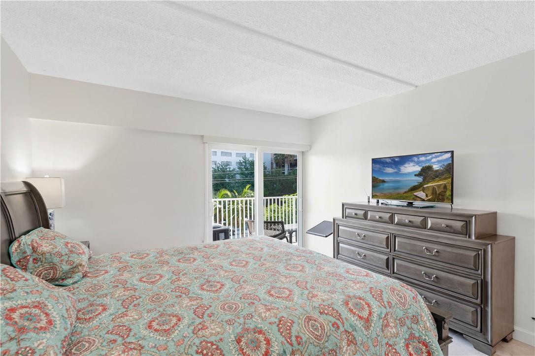 95 North Birch Road, Unit 405 Fort Lauderdale, FL 33304 - Photo 13 of 34 a bedroom with a bed and a flat screen tv