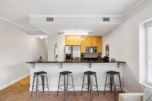 a kitchen with stainless steel appliances a table and chairs in it