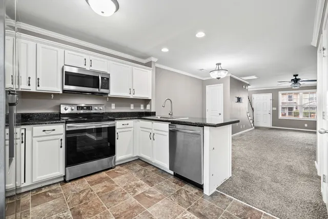 a kitchen with stainless steel appliances granite countertop a sink and cabinets