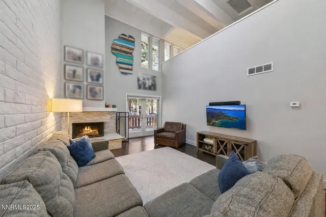a living room with furniture a fireplace and a flat screen tv