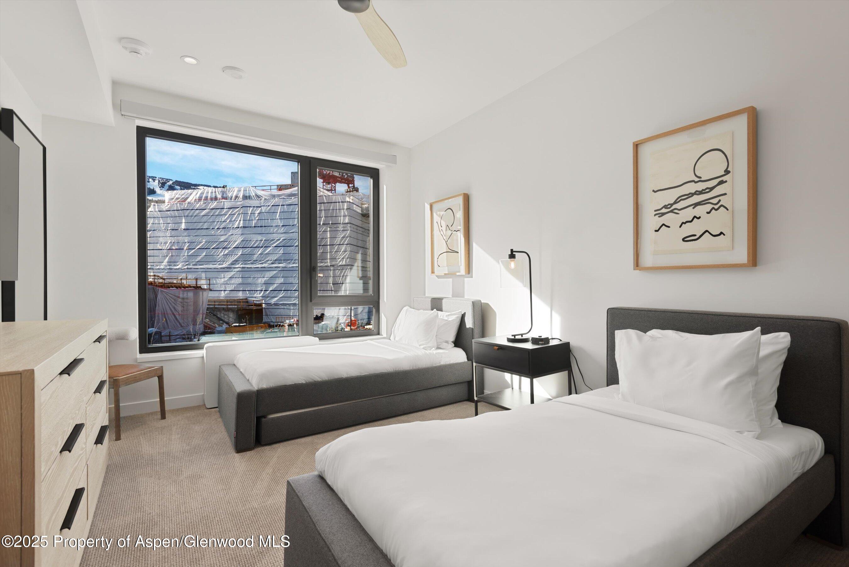 119 Wood Road, Unit 303 Snowmass Village, CO 81615 - Photo 13 of 30 a bedroom with two beds and a large window